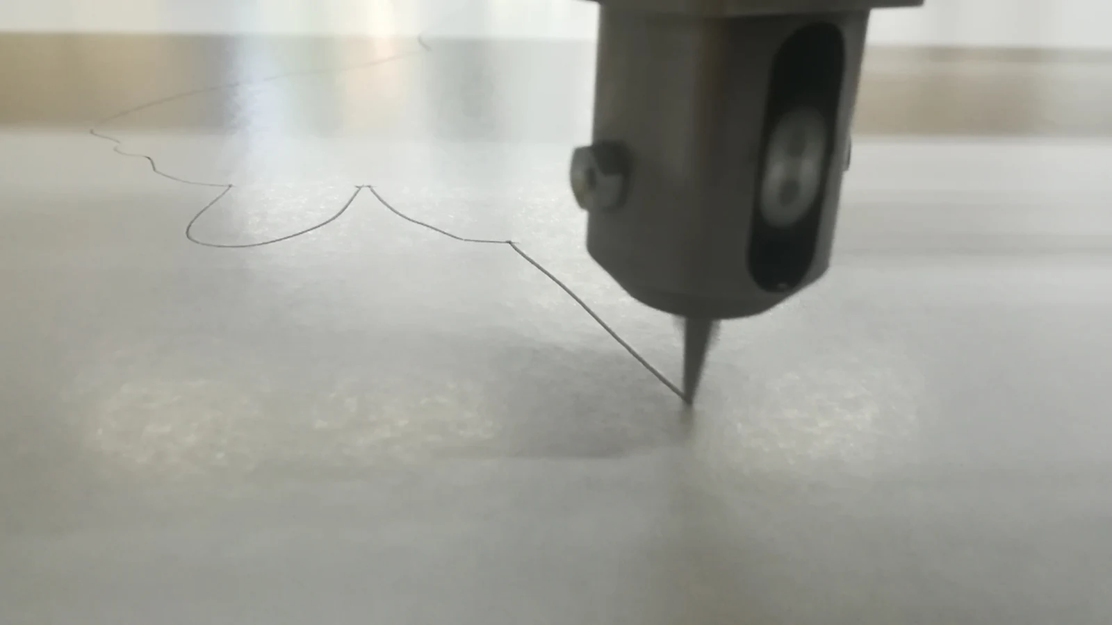 Oscillating tool cutting a curved contour in a light sheet material