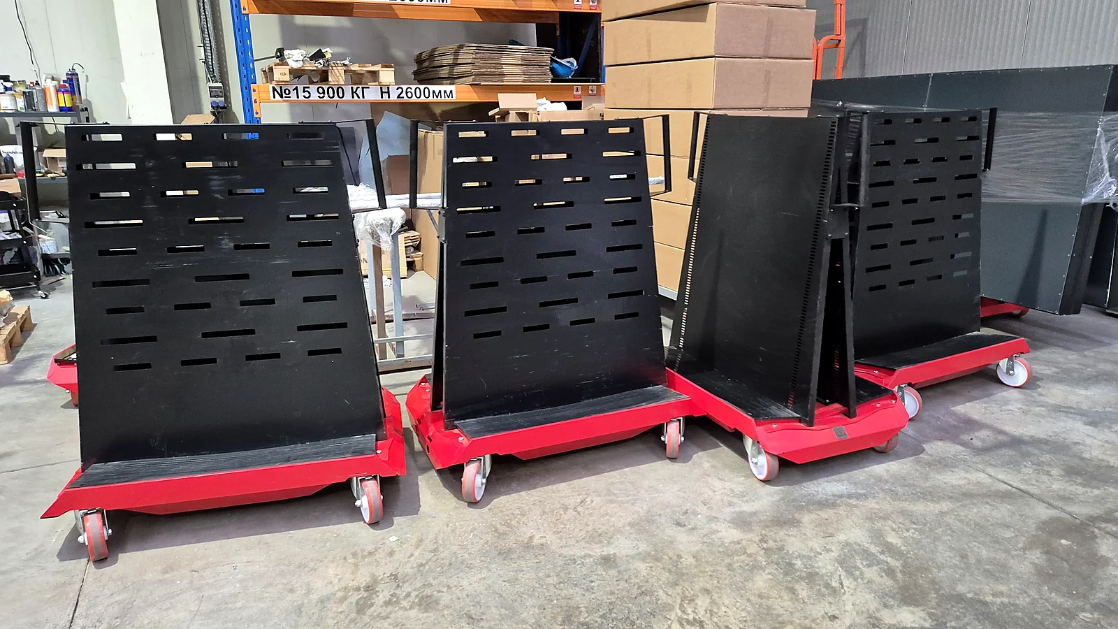Four finished red NEON SMART carts with black perforated panels in the warehouse