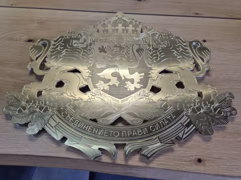 The national coat of arms, milled and engraved in a single brass sheet.