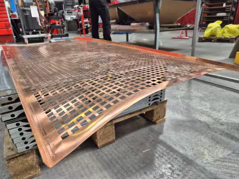 Copper sheet with a laser-cut grid — a full sheet, from the NEON.BG shop floor.