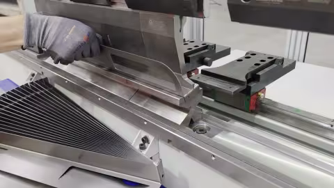 The operator bending the part from the CoastOne clip — the part in the machine